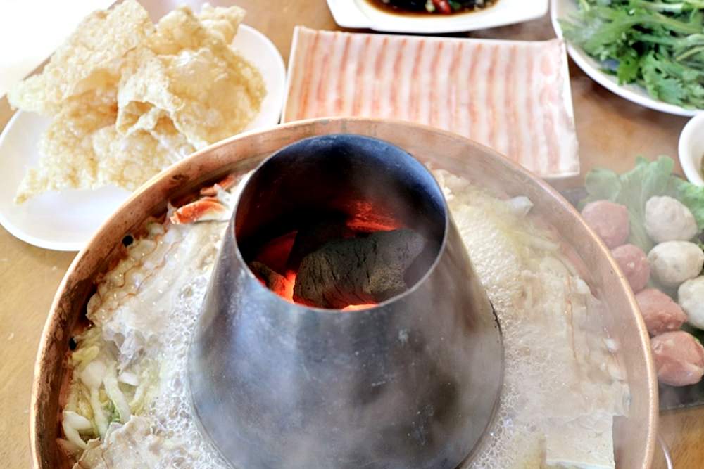 東北酸菜鍋 有煙囪的木炭銅鍋讓湯頭更香醇 白肉先燙去雜質油脂 豬肉饀餅滿飽必點